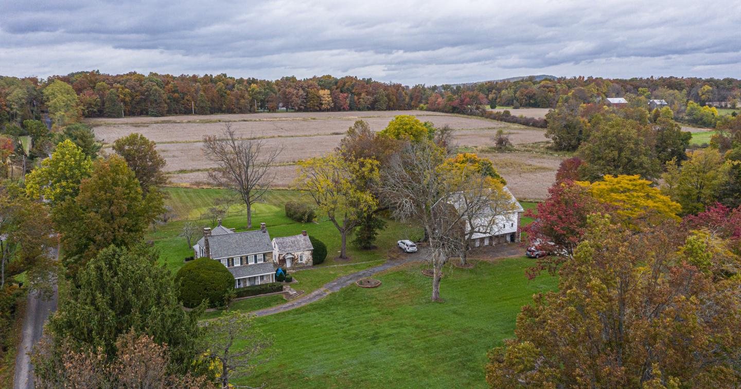 Aerial view of 1271 Birch Lane, Perkasie, a farmhouse among autumn fields